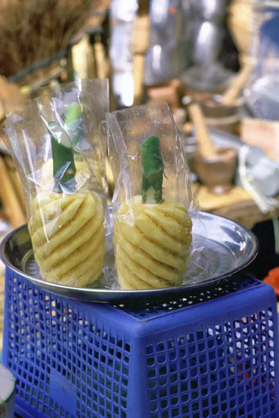 Bangkok, Thailand, Street food and market / succulent pineapple on the cart of a fruit seller in a street