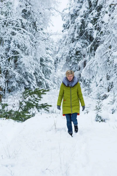 A young woman is walking through the winter forest — Stock Photo, Image