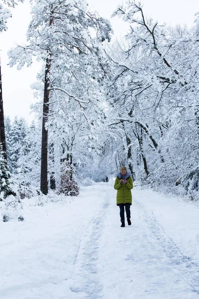 A young woman is walking in the winter forest — Stock Photo, Image