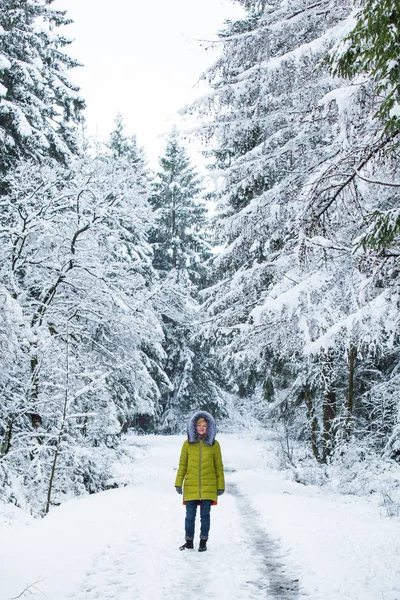 A young woman is walking through the winter forest — Stock Photo, Image