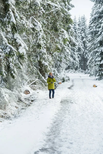 A young woman is walking through the winter forest — Stock Photo, Image