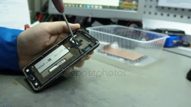 Servis Merkezi. Elektronik Onarım. Akıllı Telefon tamiri. Adam bir akıllı telefon tamiri.