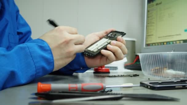 Centro de servicio. Talleres de electrónica. La reparación del teléfono inteligente. Hombre reparando un teléfono inteligente . — Vídeo de stock