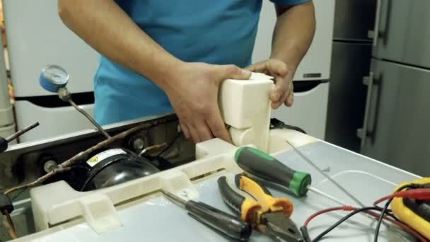 Centro de servicio. Talleres de electrónica. Un hombre repara la nevera. Soldadura de aluminio . — Vídeo de stock