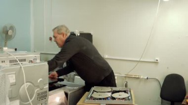 Servis Merkezi. Elektronik Onarım. Bir adam hob onarır. Multimetre.