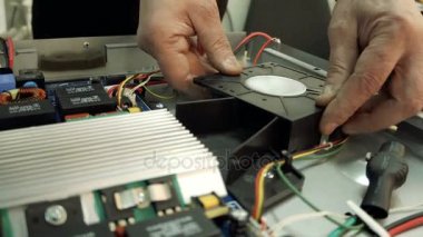 Servis Merkezi. Elektronik Onarım. Bir adam hob onarır. Multimetre.