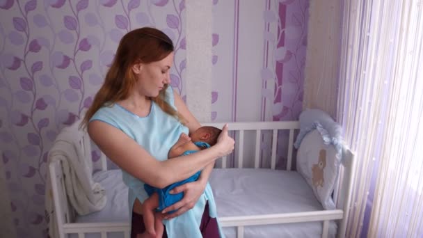 Madre joven amamantando recién nacido. Madre joven amamantando al bebé recién nacido en el dormitorio de los niños . — Vídeos de Stock