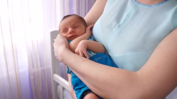 Une jeune mère berçant un nouveau-né dans ses bras . — Video