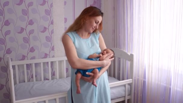 A young mother rocking a newborn in her arms. — Stock Video