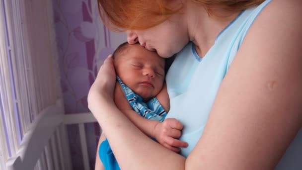 Une jeune mère berçant un nouveau-né dans ses bras . — Video