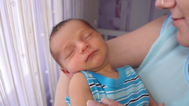 Une jeune mère berçant un nouveau-né dans ses bras . — Video