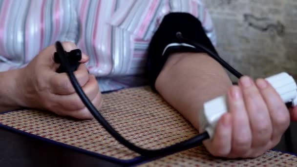 Eine Frau misst ihren Blutdruck zu Hause selbst. — Stockvideo