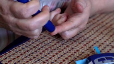 Diyabetik Olgun kadın evde onun kan glikoz düzeyi ile onun ev glikoz seti izleme denetler. Şeker Ölçüm kullanarak kan şekeri ölçümü.