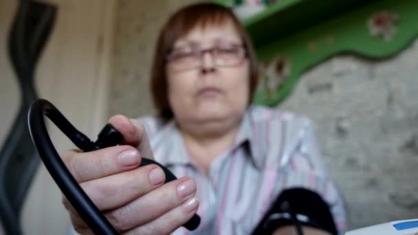 A woman self-measure blood pressure at home. — Stock Video