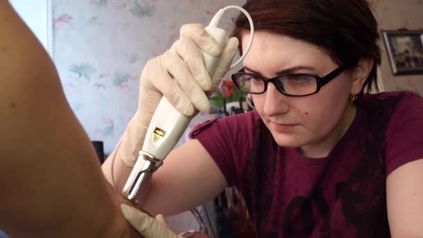 Tatuering Hårborttagning laser. En ung flicka tar bort tatuering med laser. — Stockvideo