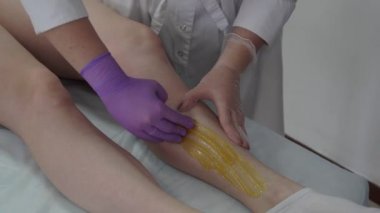 Şeker yapıştırın. Sugaring, Depilasyon. Pürüzsüz bir cilt bacaklar. Şeker ağda.