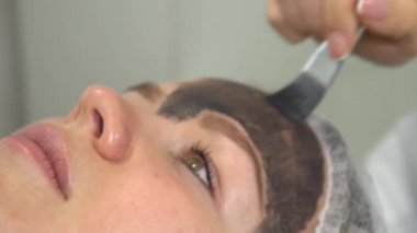 Karbon surat soyma prosedürü. Lazer darbeleri yüz derisini temizler. Donanım kozmetoloji tedavisi. Fototermoliz süreci, deriyi ısıtma, lazer karbon soyma. Yüz derisi