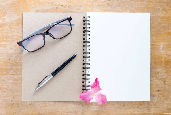 Top view of a white book placed on a wooden desk. There are pen Stock Photo