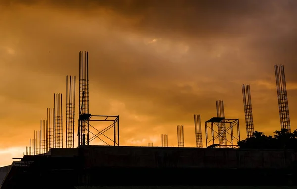 Bouw van het gebouw zuilen gewapend met stalen staven. Om te bouwen van een gebouw met een zonsondergang achtergrond. — Stockfoto