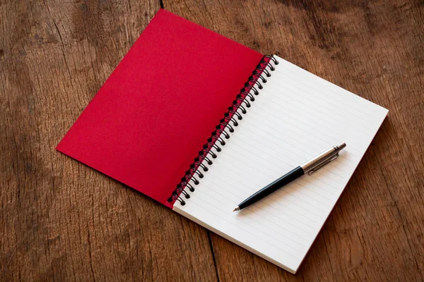 Cuaderno rojo y bolígrafo sobre fondo de textura de mesa de madera, Concepto para aprender, Con espacio de copia para agregar mensaje de texto . —  Fotos de Stock