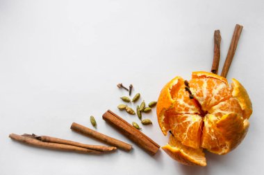 Beyaz arka planda sulu mandalina, kokulu tarçın, karanfil ve kakule karışımı.