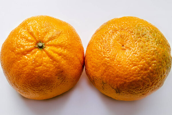 two tangerines on a white background, deployed to us by different sides