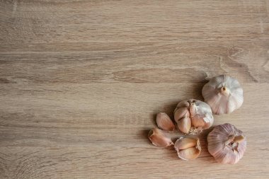 Resmin köşesindeki ahşap arka planda yakın plan sarımsak.