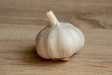 Tahta arka planda beyaz bir sarımsak.