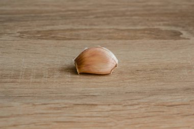 Ahşap arka planda bir diş sarımsak.