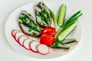 Çavdar ekmeği, tereyağı, küçük tuzlu balık, domates, turp, salatalık ve yeşil soğanlı iki lezzetli sandviç.