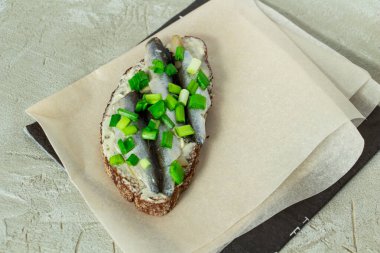 Çavdar ekmekli, tereyağlı, küçük sardalyalı ve yeşil soğanlı lezzetli sandviç.