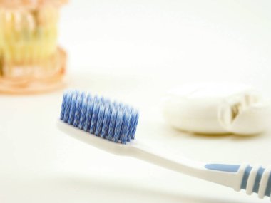 Diş modeli diş fırçası ve diş ipi beyaz arka plan üzerinde