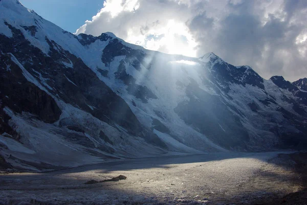 Berg och molnig himmel med solljus — Stockfoto