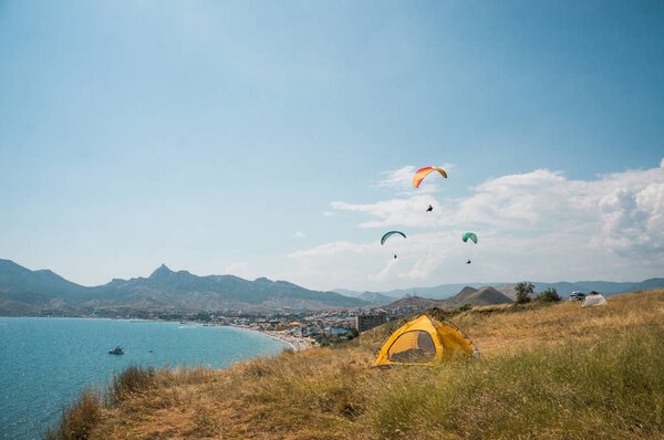 people flying on paragliders at sea