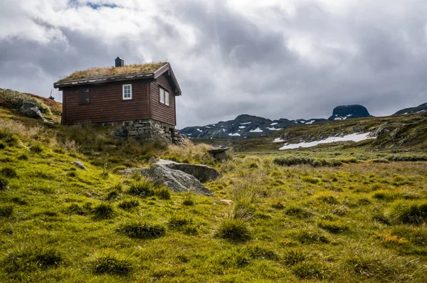 Casa no prado com montanhas — Fotografia de Stock