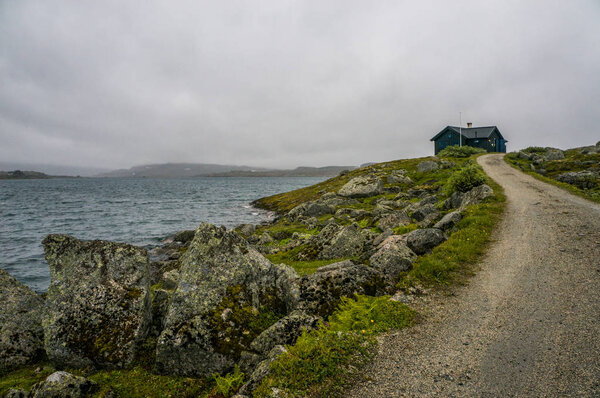 дом на лугу с дорогой и рекой
