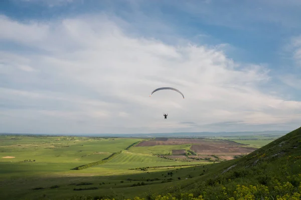 Paraglider flying above field — Free Stock Photo