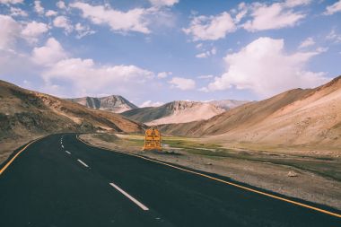 asphalt road with traffic sign in Indian Himalayas, Ladakh region  clipart