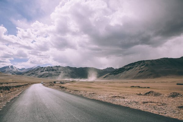 empty asphalt road in mountain valley and cloudy sky in Indian Himalayas, Ladakh region 