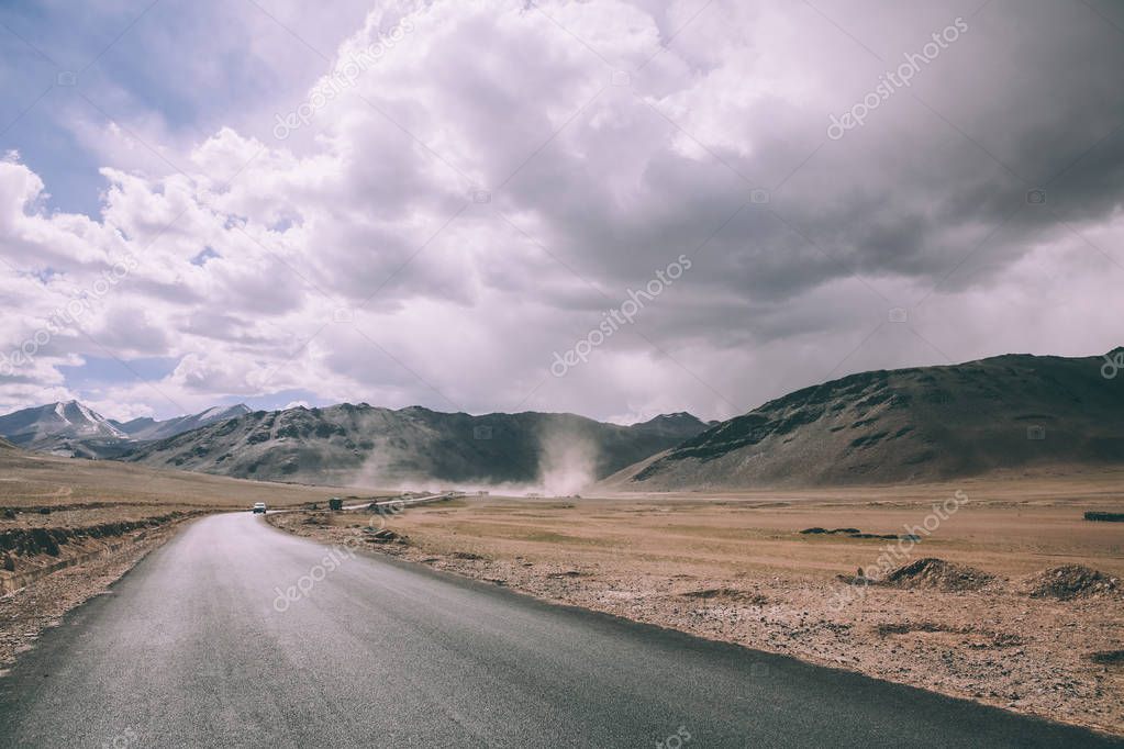 Empty asphalt road in mountain valley and cloudy sky in Indian Himalayas, Ladakh region