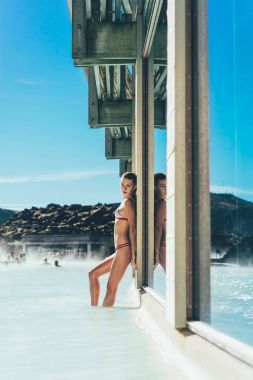 İzlanda'daki sıcak havuzda rahatlarken poz güzel genç kadın yan görünüm 
