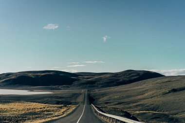 İzlanda'daki doğal tepeleri arasındaki boş asfalt yol