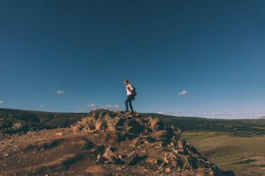 cliff ve İzlanda'daki güzel manzara üzerinde duran genç kadın 