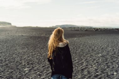 arkadan görünüşü güzel vahşi İzlanda manzara arayan genç kadın