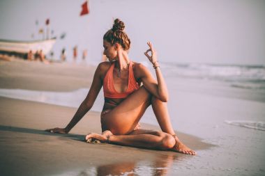 pratik yoga goa, plajda mayolu genç kadın 