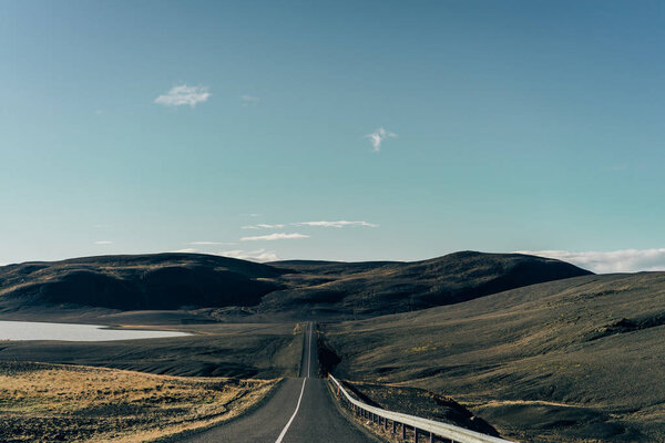 empty asphalt road between scenic hills in Iceland