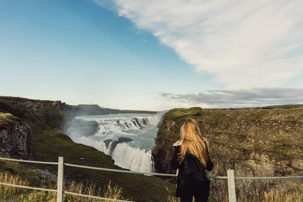 アイスランドの美しい雄大な滝を見て若い女性の背面図 — ストック写真