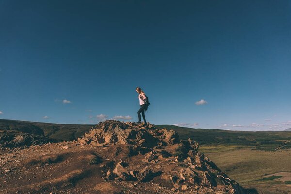 young woman standing on cliff and beautiful landscape in Iceland 