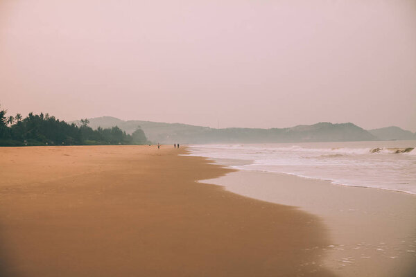 beautiful seashore with sandy beach and mountains in fog