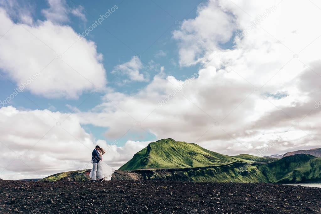 beautiful wedding couple standing together and majestic landscape in Iceland 